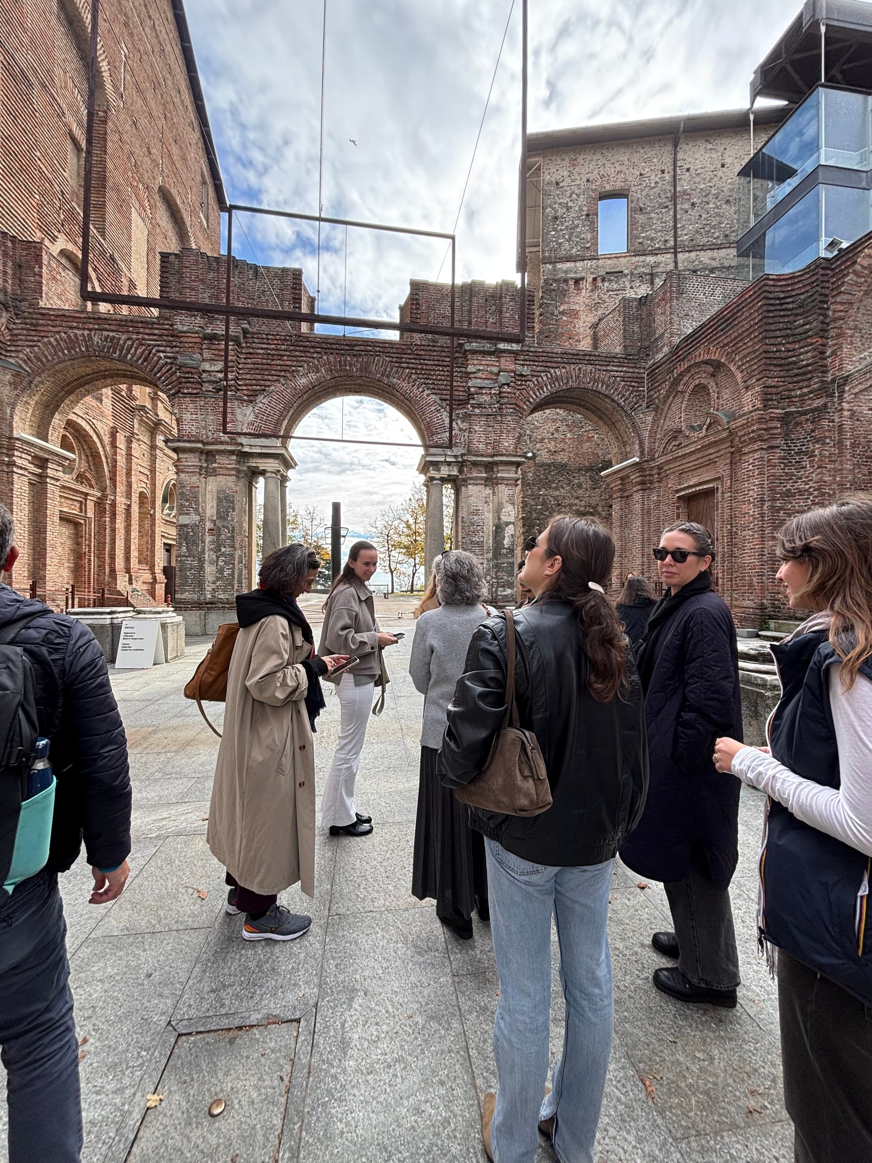 A group of curators and artists gathered inside historic ruins
